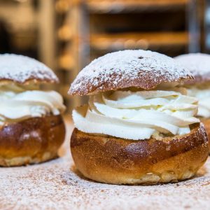 Pączek smażony z  bitą śmietaną i konfiturą z czarnej porzeczki